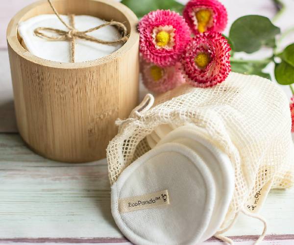 A wooden table with some flowers and a cup