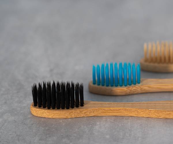 A close up of three toothbrushes on the table